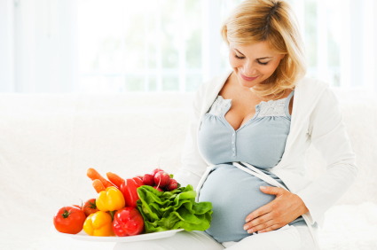 Pregnant woman with a bowl of vegetables.
